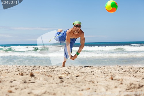 Image of attractive young man playing volleyball on the beach