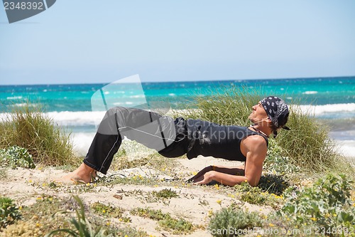Image of adult healthy man doing pilates yoga exercise 