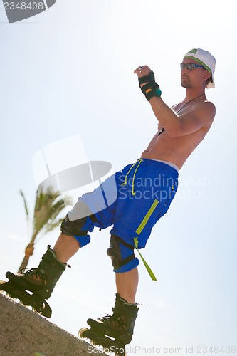 Image of young man with inline skates in summer outdoor 