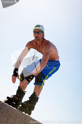 Image of young man with inline skates in summer outdoor 