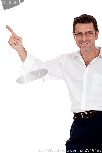 Image of adult attractive smiling man pointing his finger on the copyspace