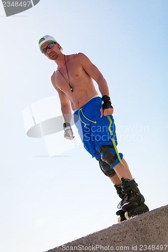 Image of young man with inline skates in summer outdoor 