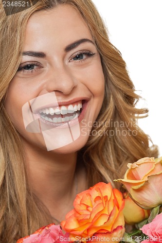 Image of attractive young smiling woman with flowers roses isolated