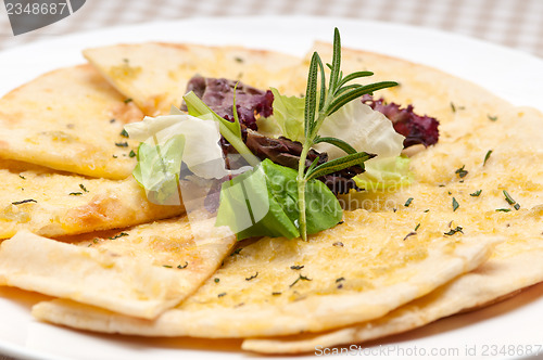 Image of garlic pita bread pizza with salad on top