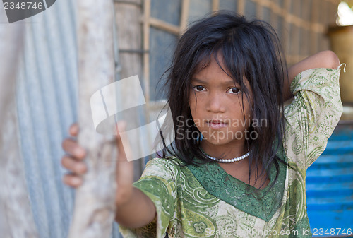 Image of A young girl lives in a fishing village and tourist poses for a 