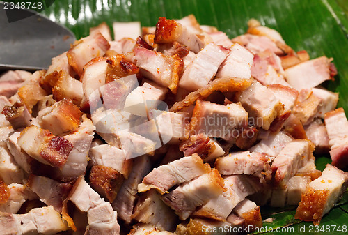 Image of Roast pork cut into pieces on palm leaf