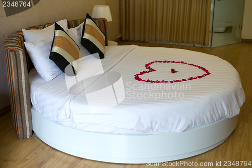 Image of Honeymoon bed topped with rose petals