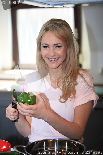 Image of Young woman preparing vegetables