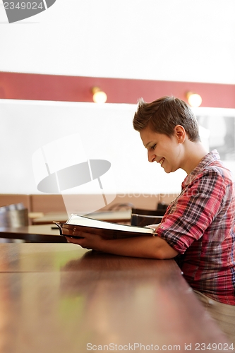 Image of Young happy woman in a restaurant