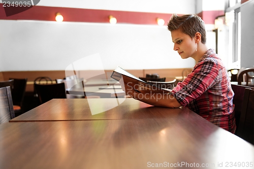 Image of Young happy woman in a restaurant