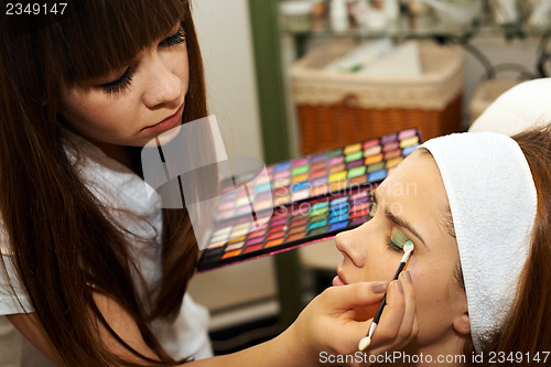 Image of Young woman getting beautiful makeup