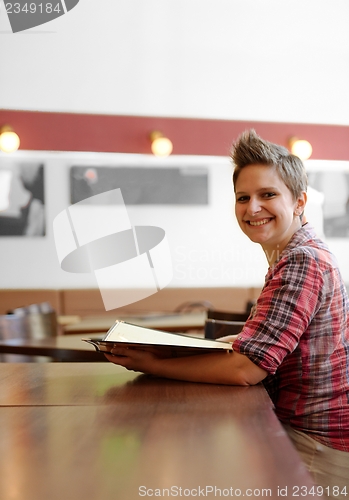 Image of Young happy woman in a restaurant