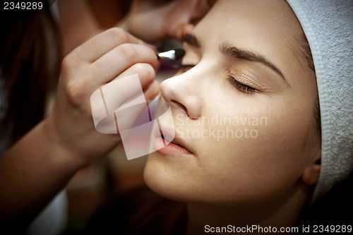 Image of Young woman getting beautiful makeup