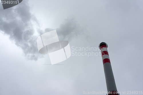Image of Industrial chimney against cloudy sky