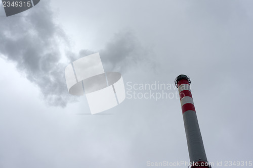 Image of Industrial chimney against cloudy sky