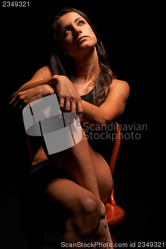 Image of Young muscular woman under bright light