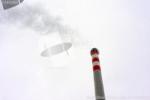 Image of Industrial chimney against cloudy sky