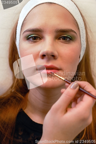 Image of Young woman getting beautiful makeup
