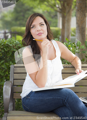 Image of Young Adult Female Student on Bench Outdoors