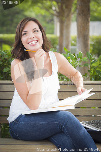 Image of Young Adult Female Student on Bench Outdoors