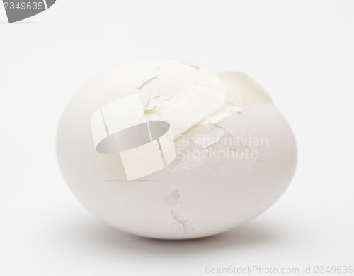 Image of Cracked white egg with plastic plaster