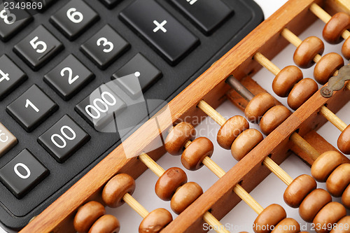 Image of Ancient abacus and modern calculator