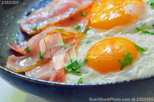 Image of fried egg with bacon in a frying pan