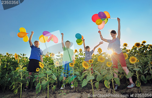 Image of happy childrens jumping on meadow with balloons