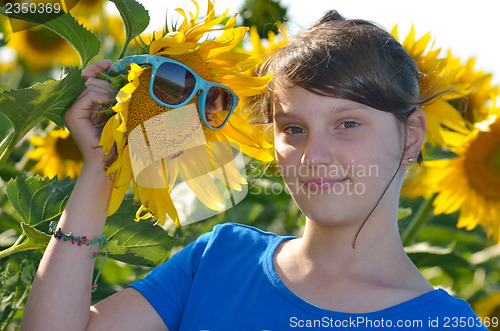 Image of Young beautiful girl in a sunflower field
