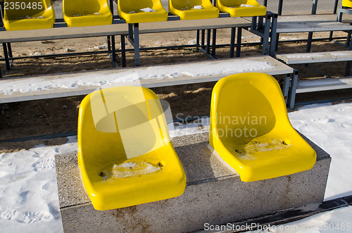 Image of two yellow plastic chairs on the cement platform 