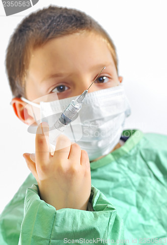 Image of doctor boy with protective mask preparing to inject 