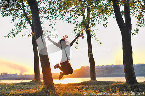Image of girl jumping over sunset