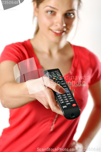 Image of young girl watching tv using a remote control