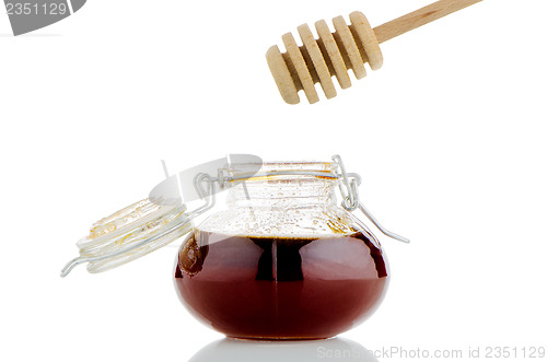 Image of Jar of honey with wooden drizzler