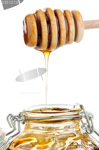 Image of Jar of honey with wooden drizzler