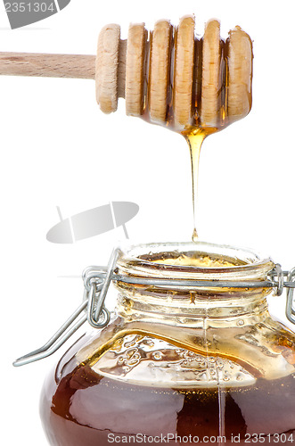 Image of Jar of honey with wooden drizzler