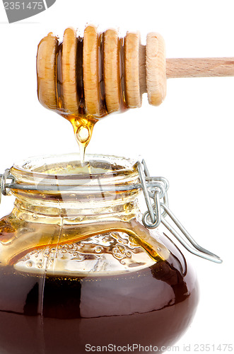 Image of Jar of honey with wooden drizzler