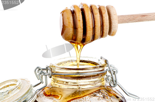 Image of Jar of honey with wooden drizzler