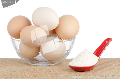 Image of Brown eggs on brown and red ceramic spoon with white powder