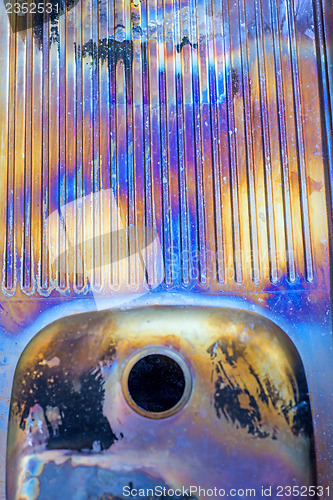 Image of old corrugated sink with rainbow colors