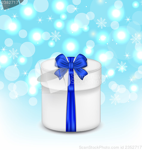 Image of gift box with blue bow on glowing background