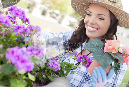 Image of Young Adult Woman Wearing Hat Gardening Outdoors
