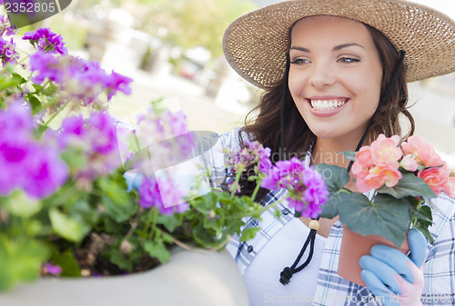 Image of Young Adult Woman Wearing Hat Gardening Outdoors