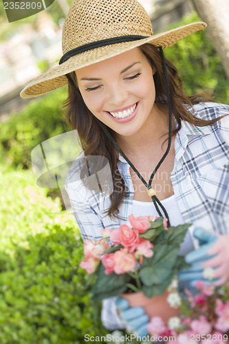 Image of Young Adult Woman Wearing Hat Gardening Outdoors