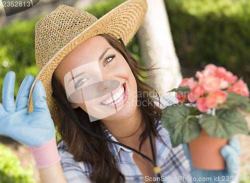 Image of Young Adult Woman Wearing Hat Gardening Outdoors