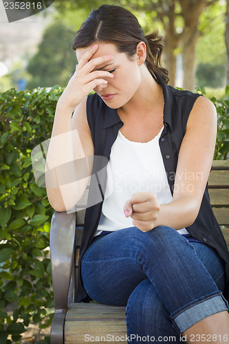 Image of Upset Young Woman Sitting Alone on Bench