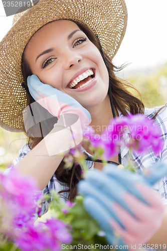 Image of Young Adult Woman Wearing Hat Gardening Outdoors