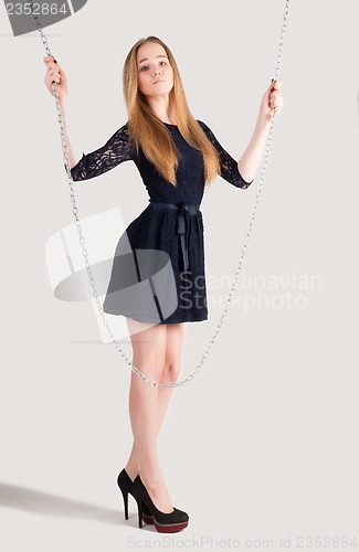 Image of beautiful fashionable woman near chain swing