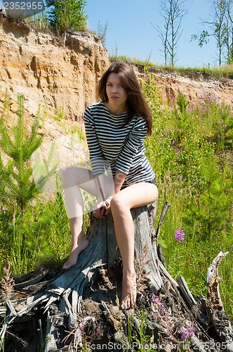 Image of portrait of young beautiful woman on stump