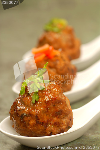 Image of Asian styled meatballs on spoons with a variety of toppings